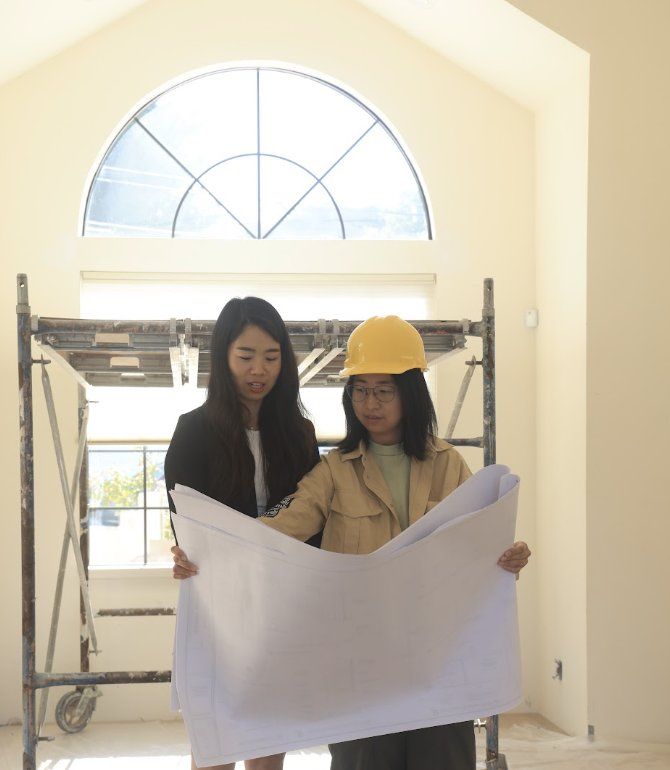 Two Greenland team members reviewing building plans on site